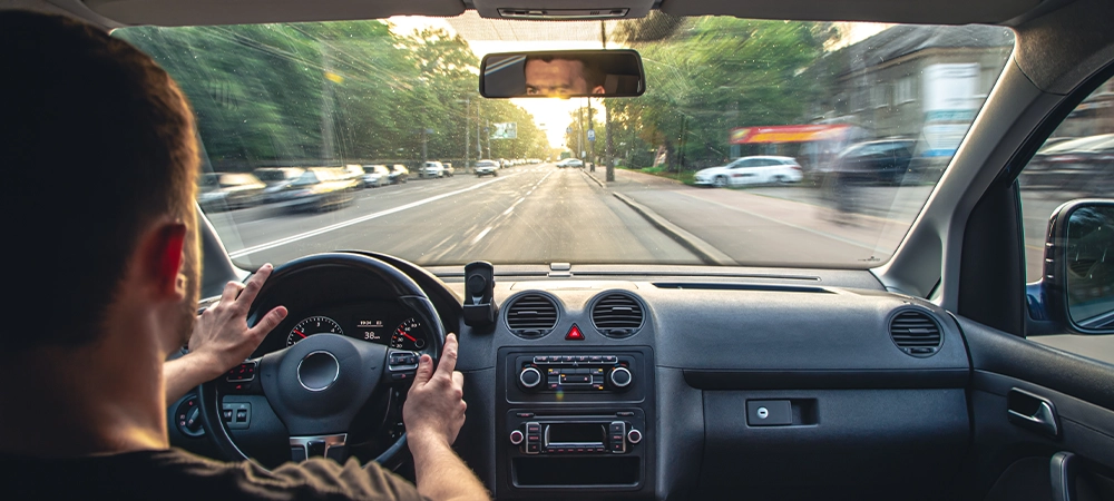 man driving a car on road carefully